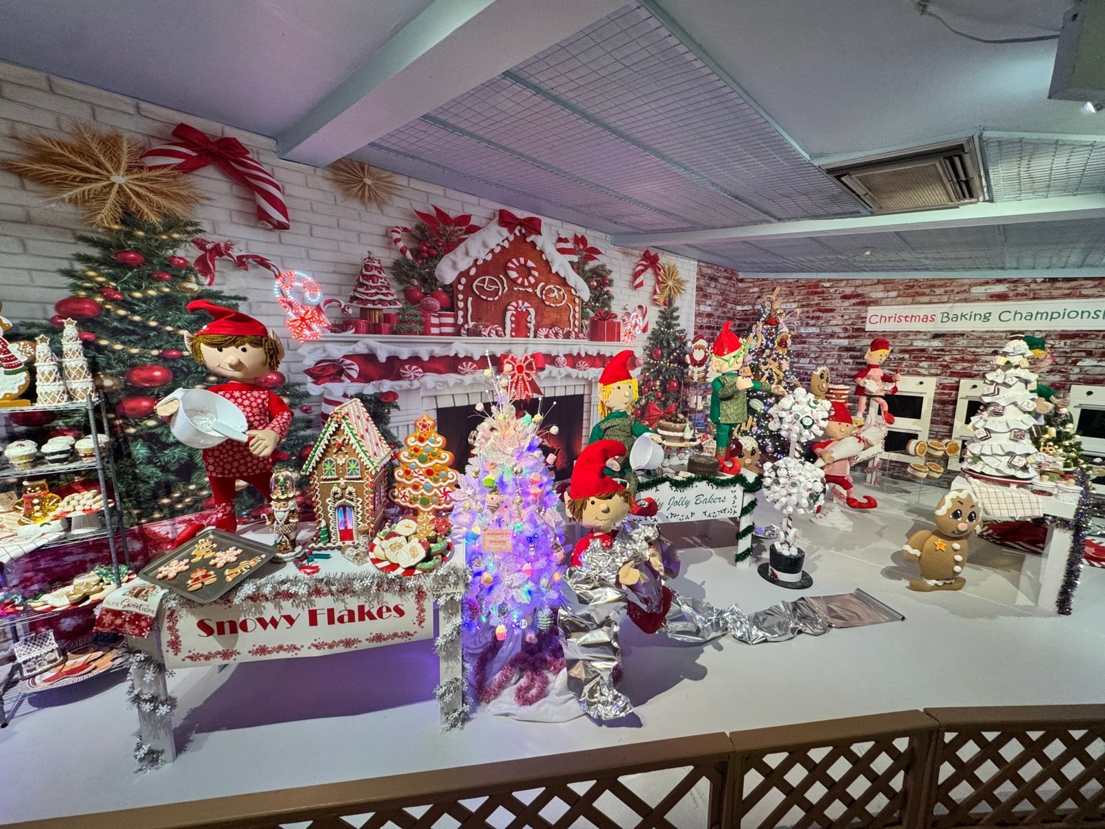 Elf bakers at gingerbread and cookie tables in the Christmas Baking Championship scene