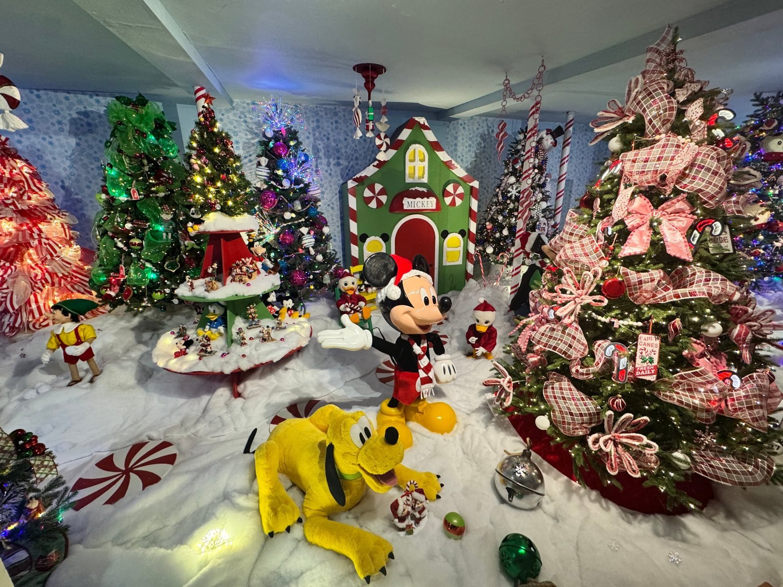 Mickey Mouse and Pluto in a snowy peppermint candy village scene